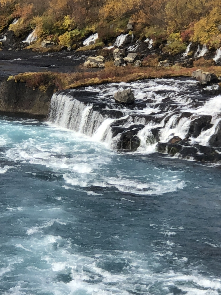 Small cascading waterfall with blue water.