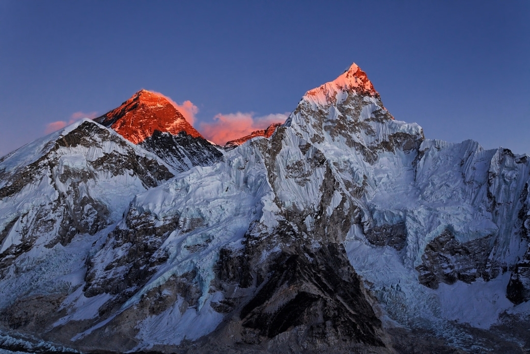 Snow-capped mountain peaks illuminated by warm light.