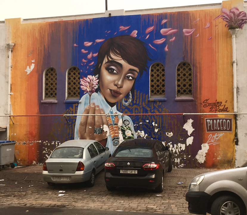 Vibrant mural with a portrait of a woman on a building wall.