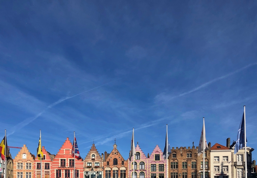 Colorful gabled rooftops under a clear blue sky.