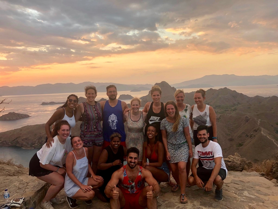 Group of people with a scenic sunset view in the background.