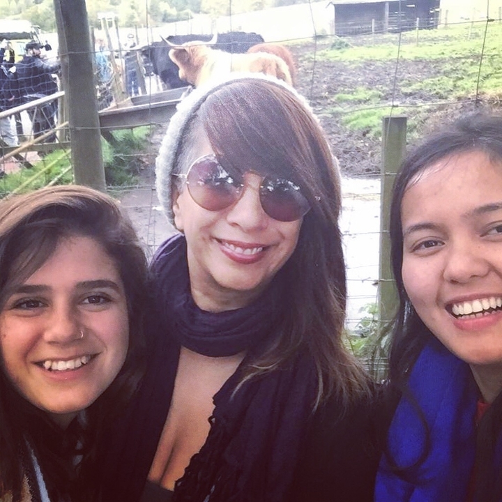 Femmes souriantes pour un selfie à côté d'une clôture.