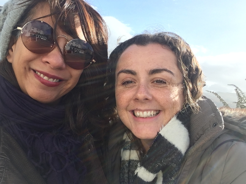 Deux femmes souriant pour un selfie à l'extérieur.