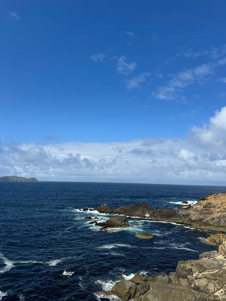 Rocky coastline with blue ocean and sky.