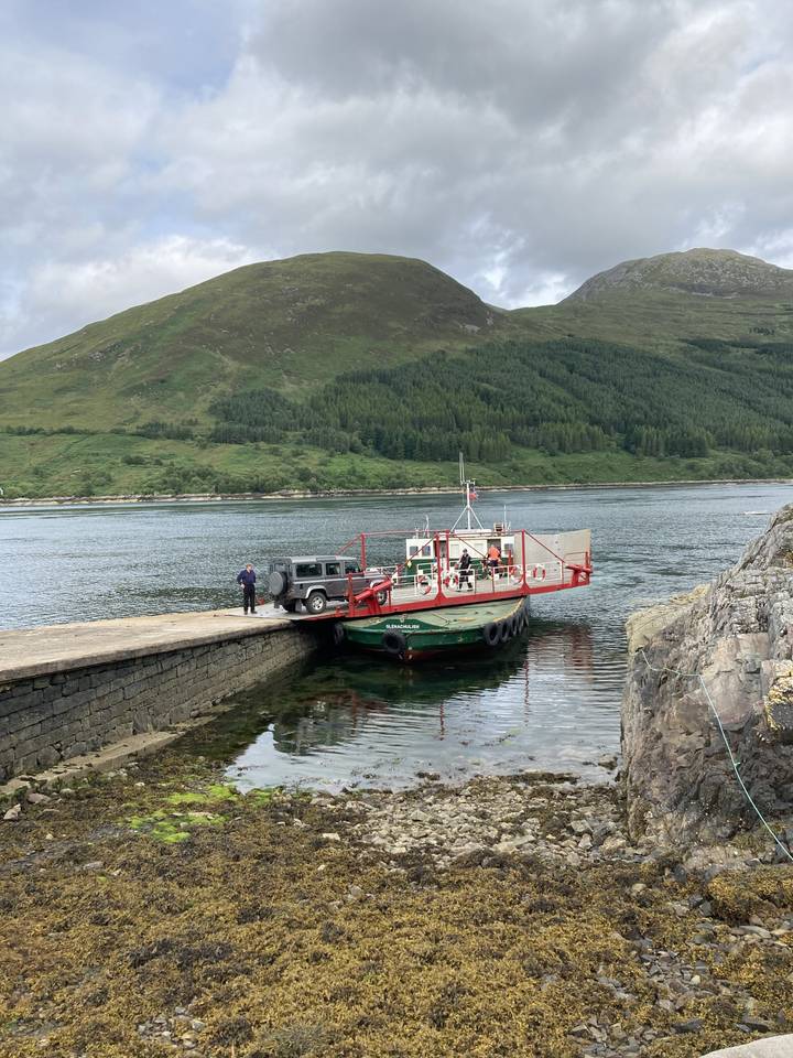 Boat docked on a shore surrounded by mountains.