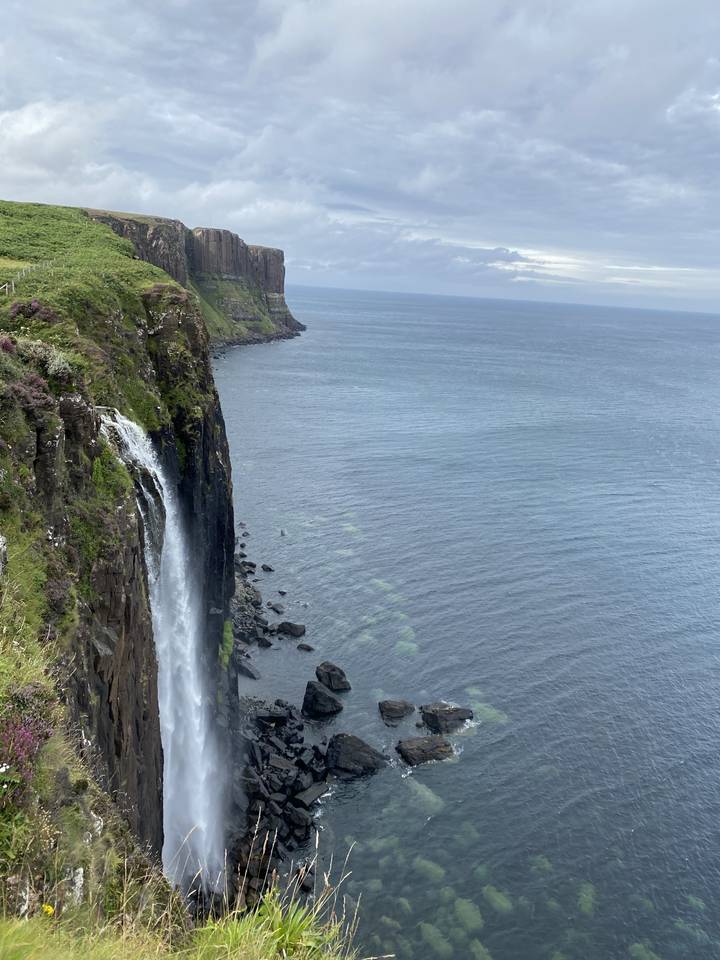 Cascade et falaises rocheuses au bord de l'océan.