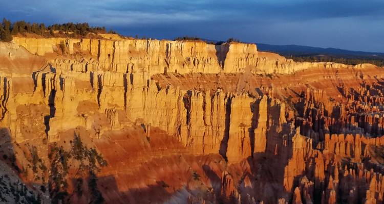 Dramatic cliffs with layered rock formations at sunset.