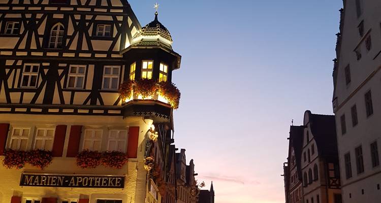 Een historisch gebouw met ingewikkelde architectuur verlicht in de nacht.