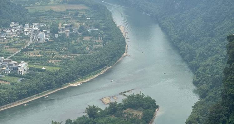 A river winding through lush green landscapes and mountains.