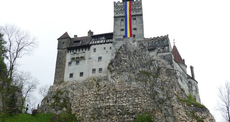 Burg auf einem felsigen Hügel mit einer großen Flagge.
