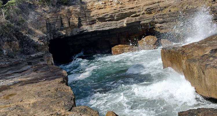 Rocky coastal scenery with a waterfall.