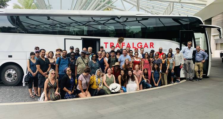 Group photo in front of a tour bus labeled 'Trafalgar'.