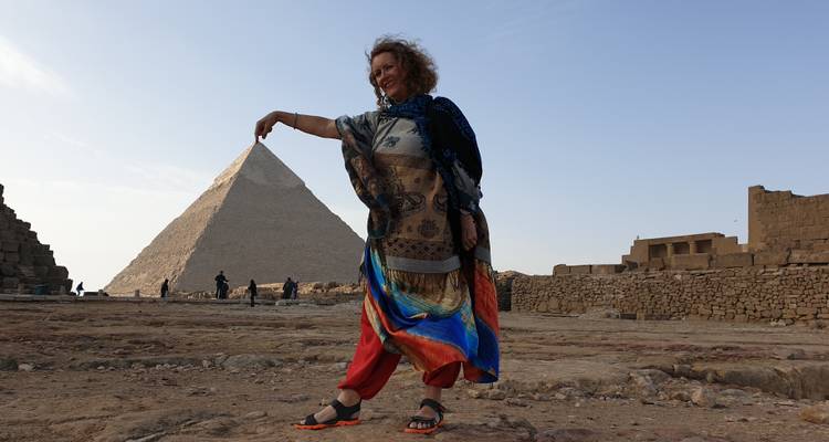 Femme imitant tenir le sommet d'une pyramide à distance.