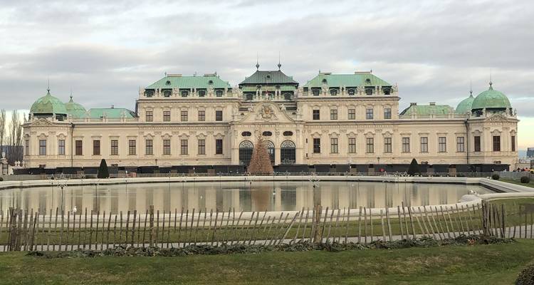 Ein großartiges Gebäude mit grünen Kuppeln und einem großen Wasserbecken davor.