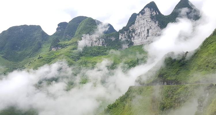 Misty mountains with clouds in a lush green landscape.