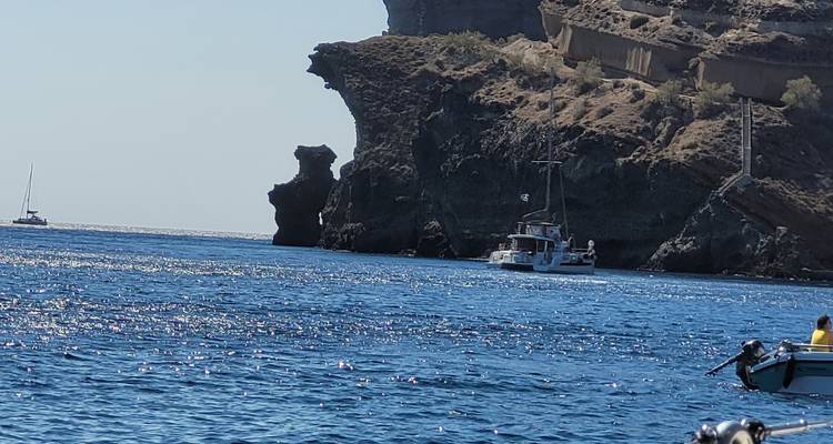 Bateau naviguant le long d'une côte rocheuse.