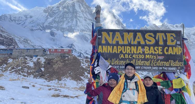 Group of people at the Annapurna Base Camp with mountain in the backdrop.