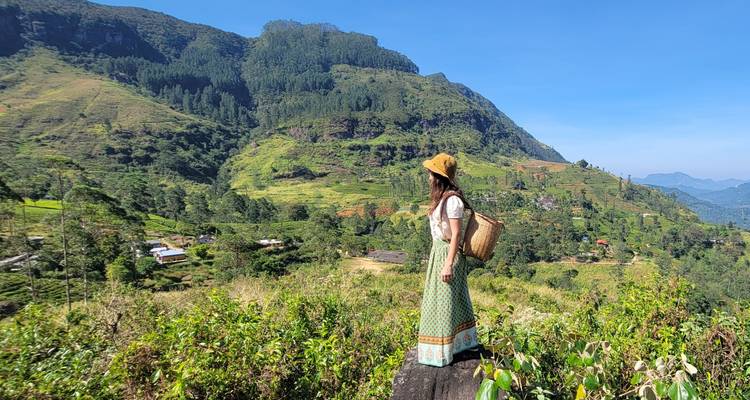 A woman standing on a hill with scenic views.