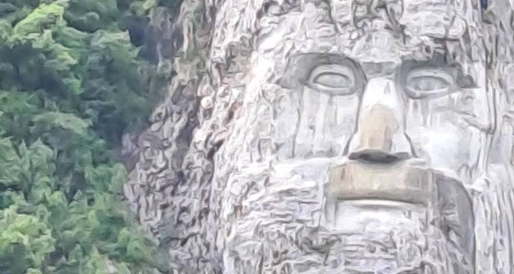 A large rock sculpture of a face in the mountainside.