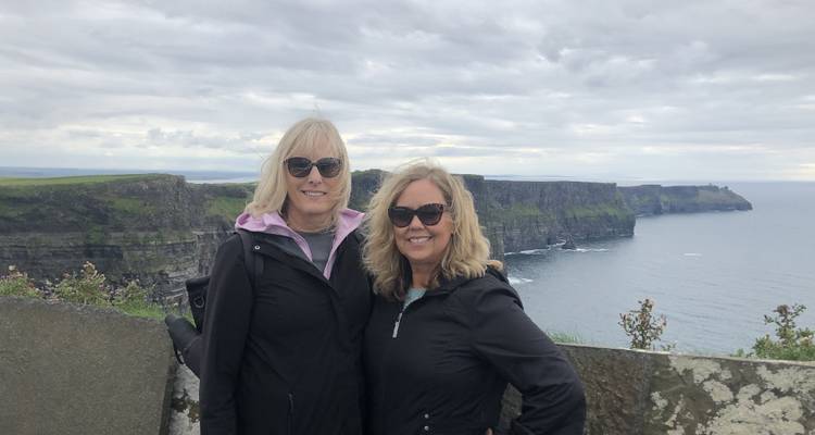 Twee vrouwen staan voor de Cliffs of Moher.