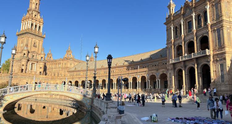 Plaza with historic buildings and people walking around.