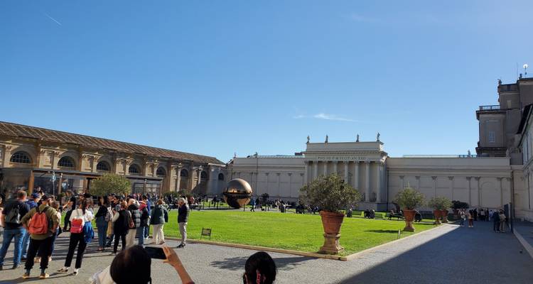 Foules devant les Musées du Vatican avec la sculpture sphérique.