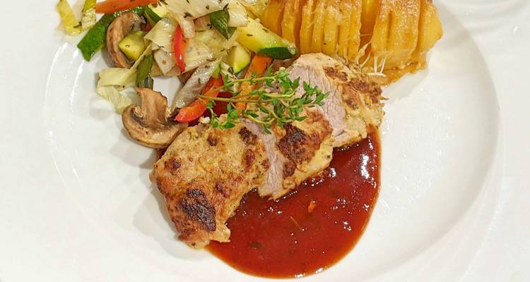 Assiette de viande et pommes de terre accompagnée de légumes.