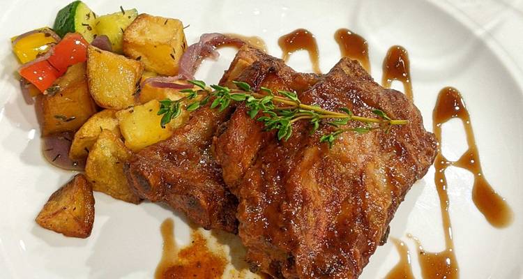 Assiette de côtes avec pommes de terre rôties.