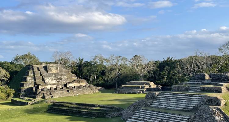 Ancient ruins with stepped pyramid structures under a clear blue sky