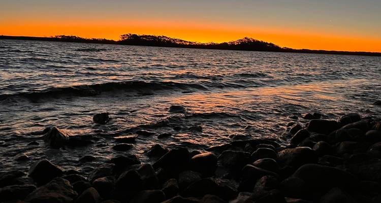 Costa rocosa al atardecer con iluminación estilo silueta.