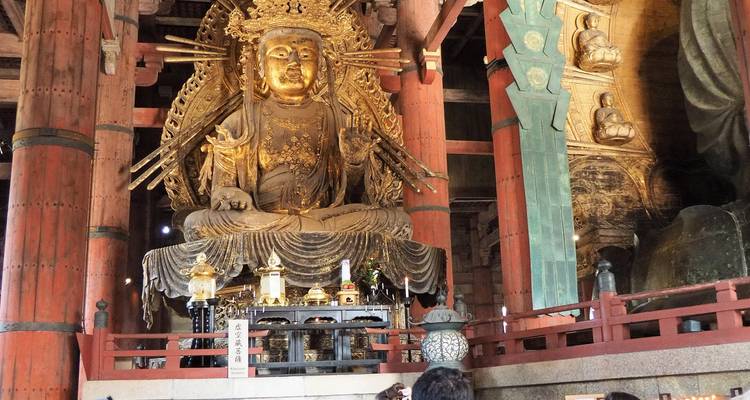 Statue de Bouddha à l'intérieur d'un temple aux motifs complexes.