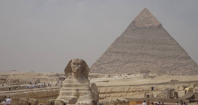 The Great Sphinx and Pyramid of Giza under a cloudy sky.