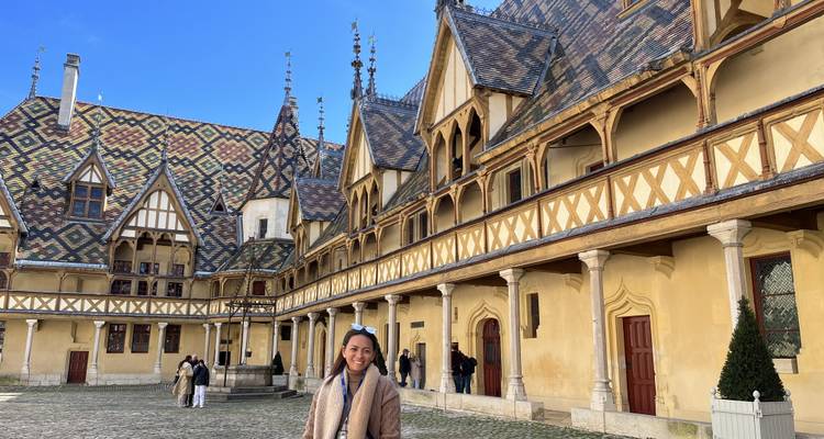 Persona parada frente a un edificio histórico con azulejos decorativos.
