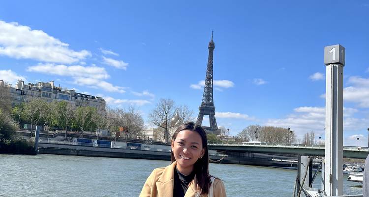 Persona posando junto a la Torre Eiffel.