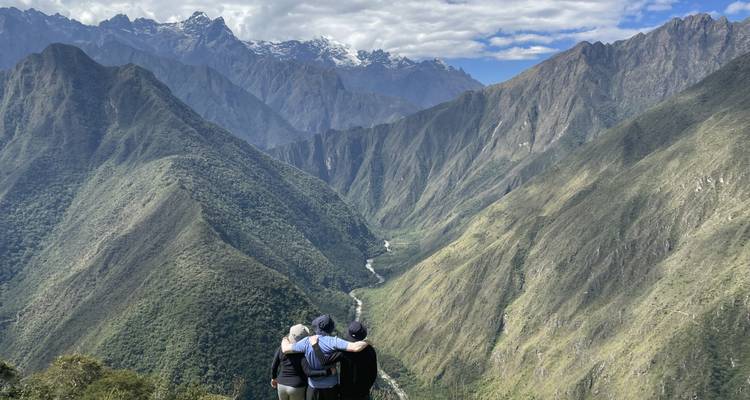 Des gens qui s'enlacent en regardant une vallée de montagne pittoresque.
