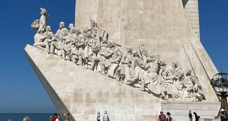 Monument présentant des statues d'explorateurs avec un ciel bleu en arrière-plan.