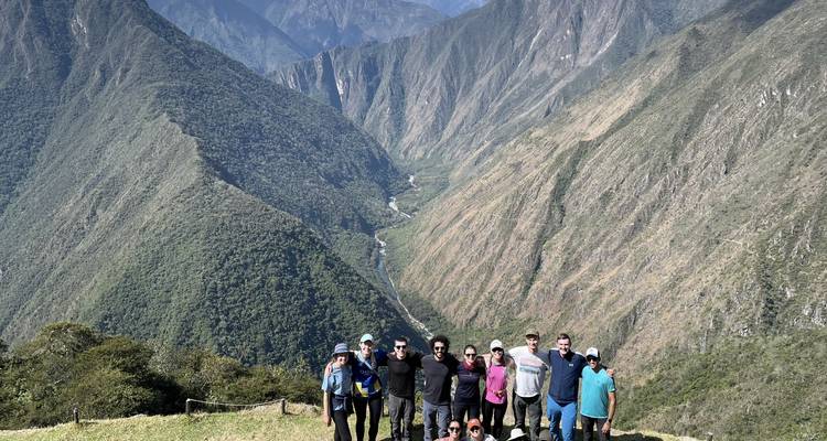 Un groupe de randonneurs posant avec un paysage montagneux époustouflant.