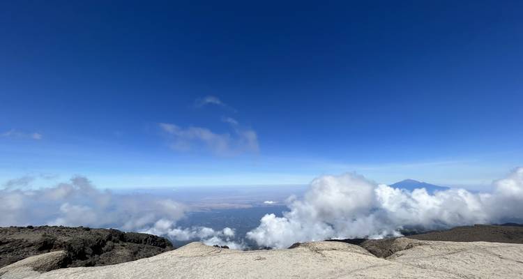 Vue grand-angle de nuages sous un sommet de montagne.