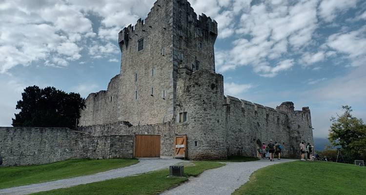 Een historisch kasteel met toeristen buiten.