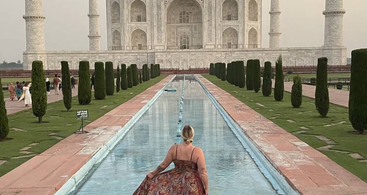 Taj Mahal avec une femme profitant de la vue depuis le bassin de réflexion.
