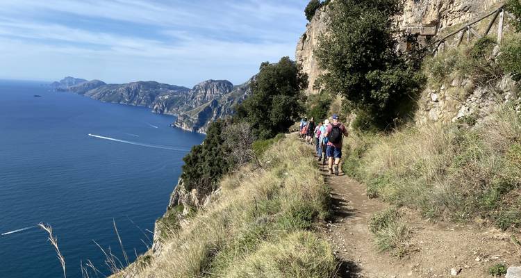 Wanderer, die einen Küstenwanderweg entlanggehen.