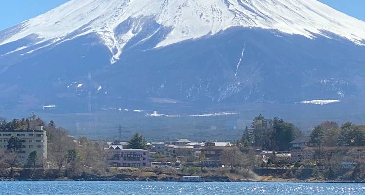 Le mont Fuji qui domine une ville au bord d'un lac.