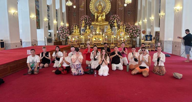 Grote groep mediterend in een gouden tempel.