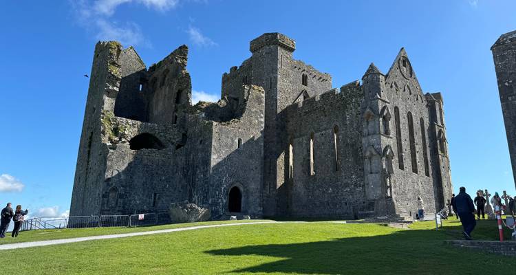 Imposant stenen kasteel tegen een blauwe hemel.