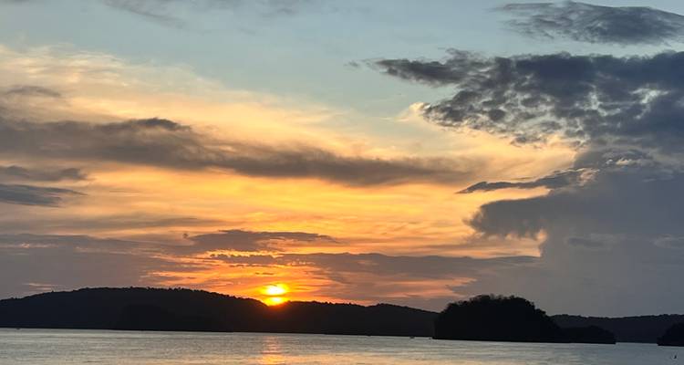 Beautiful sunset with the sun setting over the horizon and dramatic clouds.