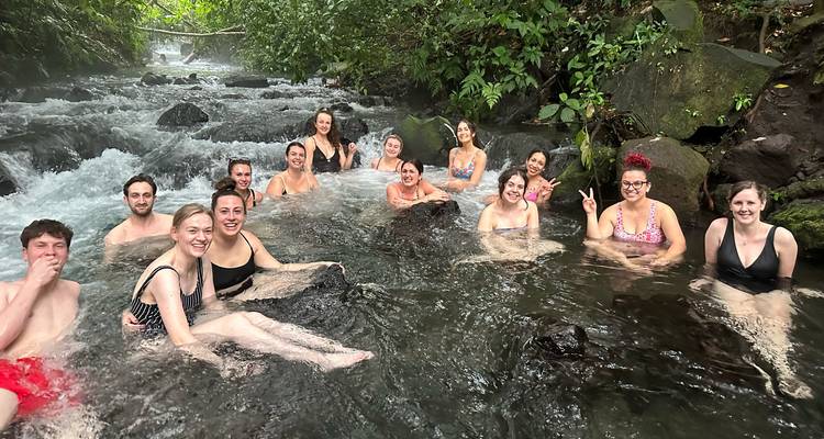 Groupe de personnes se détendant dans une source chaude naturelle.