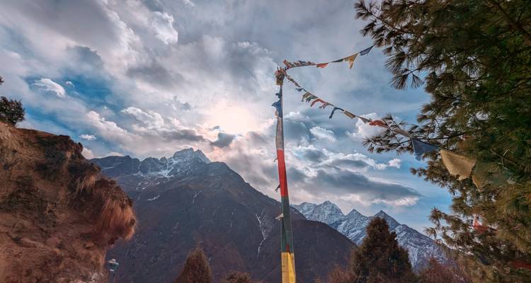 Nuée de drapeaux de prière avec un paysage de montagne époustouflant en arrière-plan.