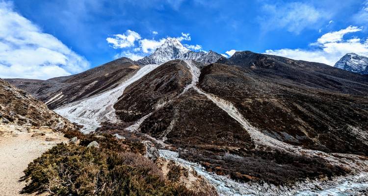 Paysage montagneux expansif avec des pentes escarpées et un ciel dégagé.