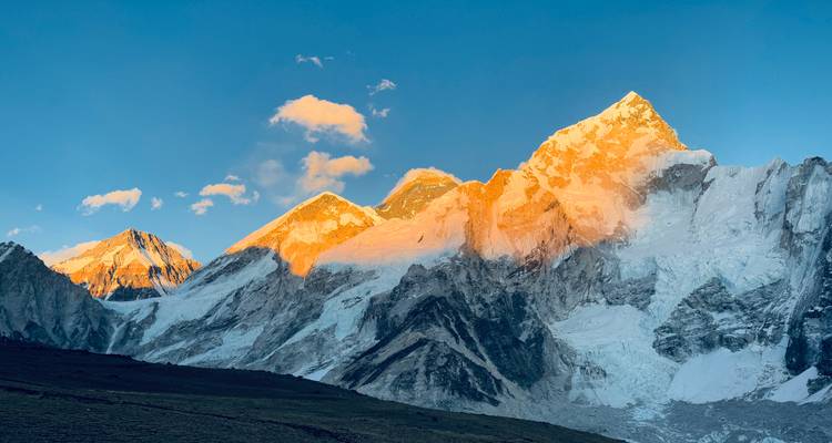 Coucher de soleil illuminant une chaîne de montagnes spectaculaire couverte de glace.