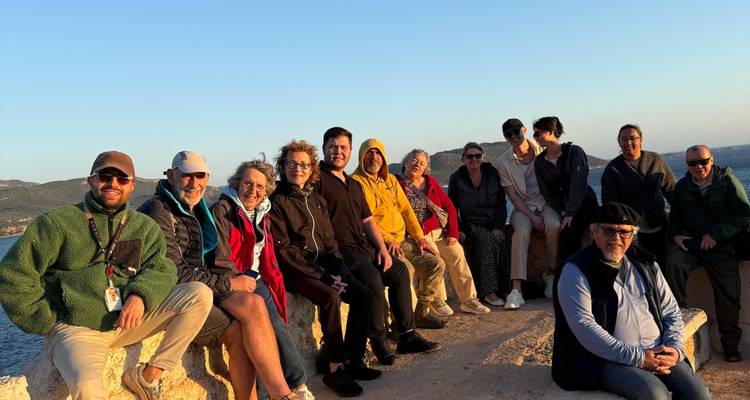 Group of people sitting at a scenic viewpoint.